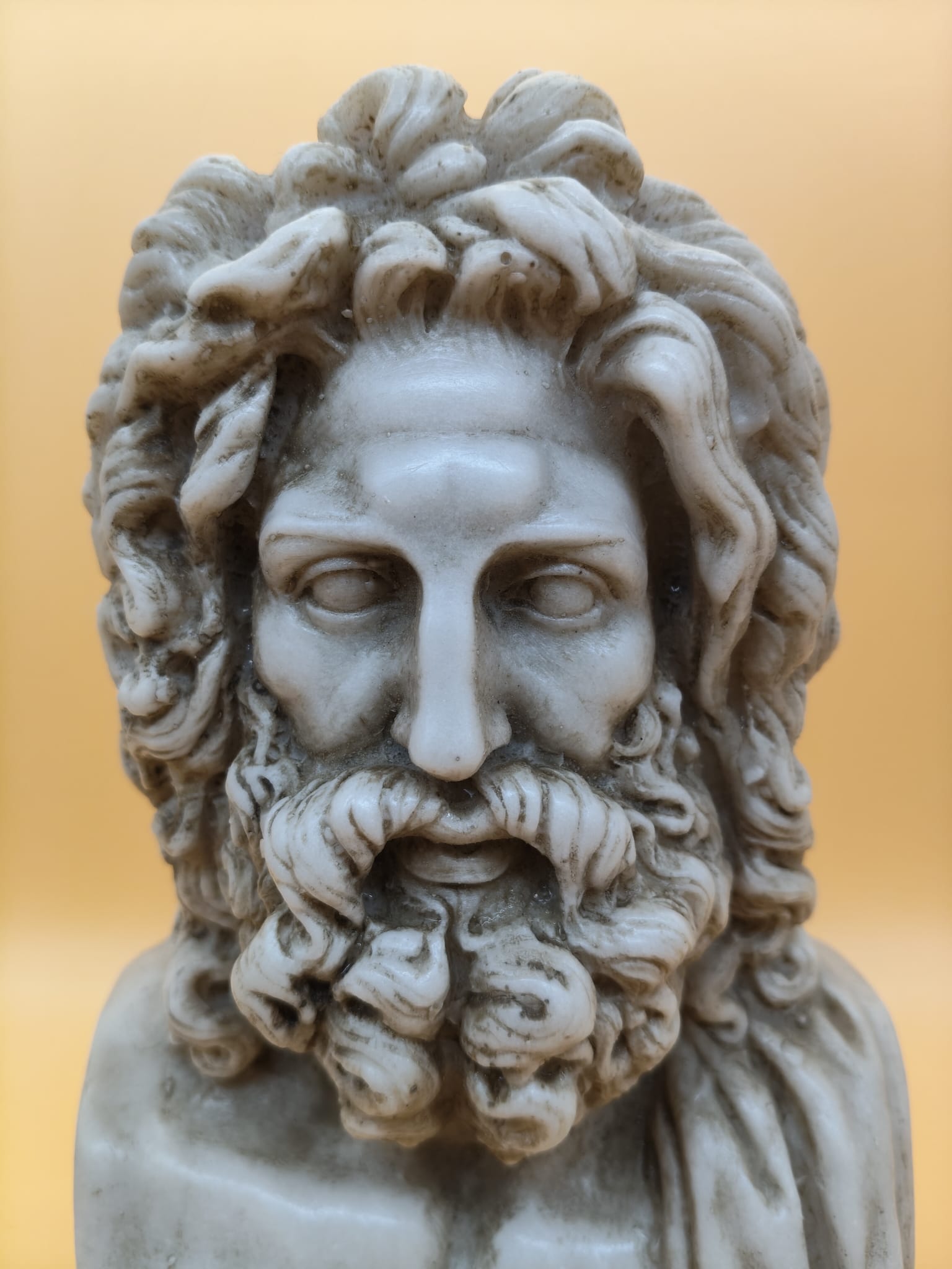 Detalle del busto de Zeus en polvo de mármol y base con inscripción